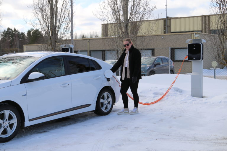 Henkilö lataamassa sähköautoa